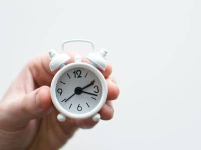 A hand holding a clock